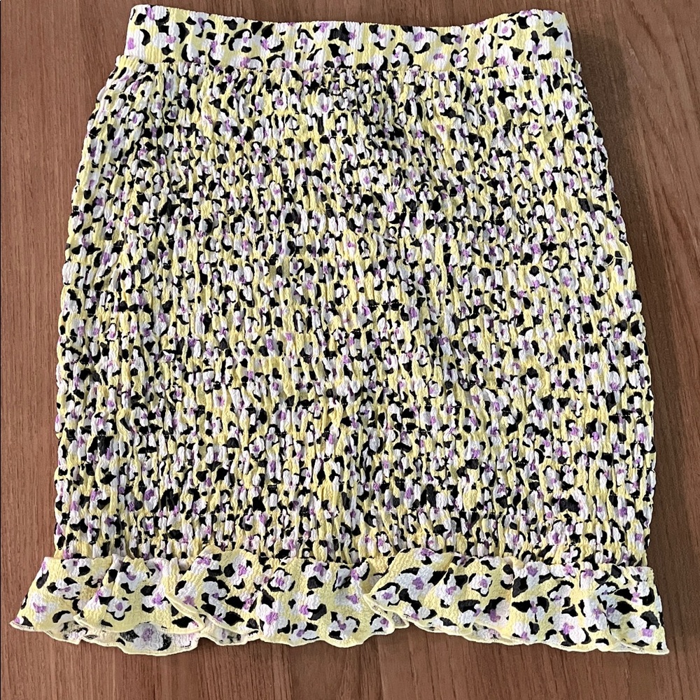 Soft yellow knee length skirt with hints of lavender and black. Size M